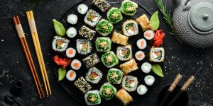 Set of traditional sushi on a black plate. Sushi and rolls on a dark background.